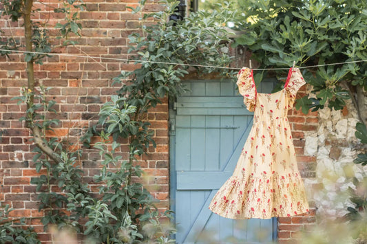 A yellow dress hanging on a line outside a building